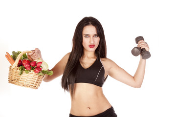 Woman holding vegetables and weights up