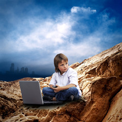 Child with laptop on the mauntain under sky with clouds