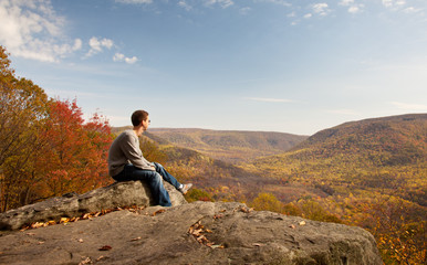 Young hiker relaxing on rock