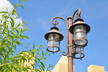 A brown metal trio retro streetlamp at a park