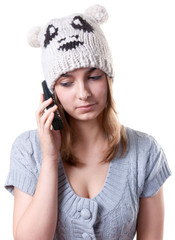 Beautiful girl in winter hat with telephone