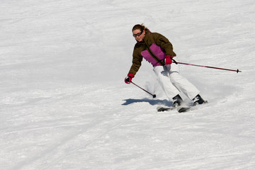 Woman downhill skiing on wide piste