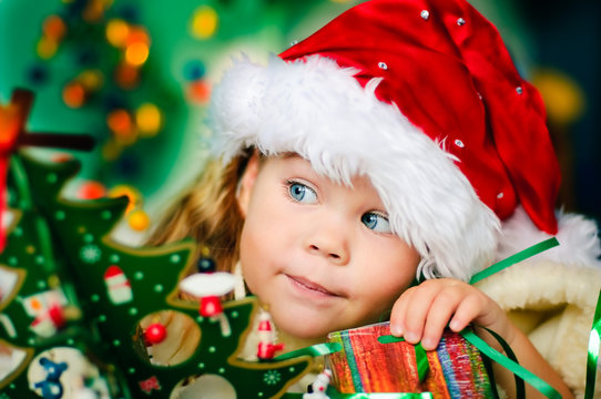 Happy small girl in santa hat have a christmas