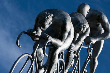 Trois cyclistes en compétition, détail d'une immense sculpture