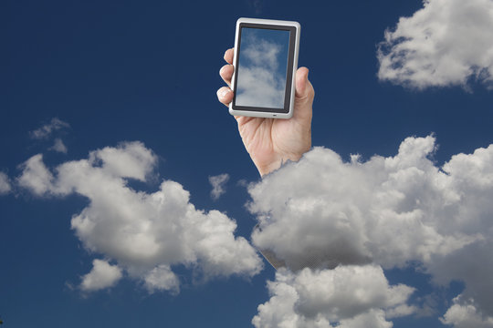 Hand Holding Cell Phone In Cloudy Sky