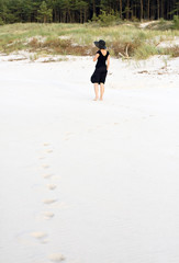 Młoda piękna kobieta spacerująca po plaży