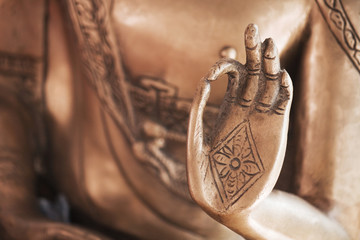 De hand van de koperen Boeddha