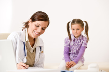 Female doctor write prescription for child