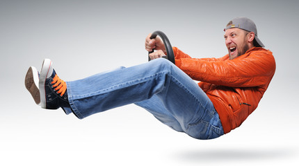 Fast man driver with a wheel in orange jacket, concept - obrazy, fototapety, plakaty