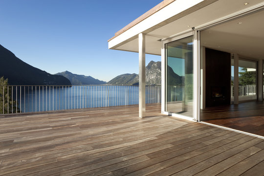 Terrazza di casa moderna con vista su lago e montagne.