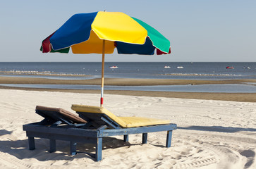 Beach lounge chairs and umbrellas along the shoreline
