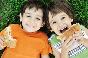 Two cute boys laying on ground in nature and happy