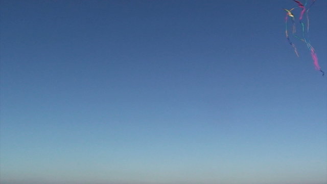 Flying kite against a vivid blue sky
