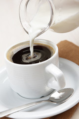 Pouring milk into coffee