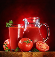 Jug and glass full of tomato juice.