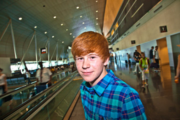 boy on a moving staircase inside the airport