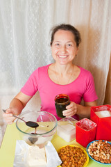 woman adds honey into dish with sugar.  Cooking of  honey cake