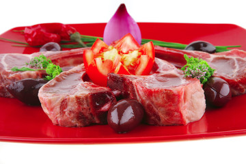 uncooked ribs on red plate