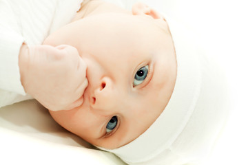 little baby boy in white hat over white