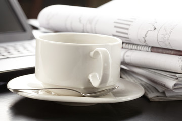 Cup of fragrant coffee on a morning paper business news