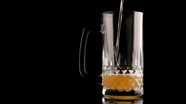 Beer Poured In Glass On Black Background