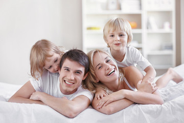 Obraz premium Smiling parents with children at home