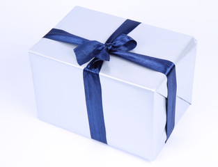 Gift in silver wrapping with a blue bow on white background
