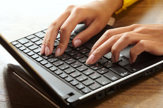 Female hands typing on a laptop
