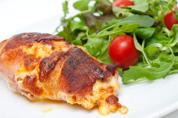 chicken wrapped in bacon served with salad