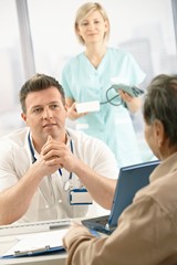 Fototapeta premium Doctor talking to elderly patient