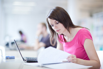 in the library - pretty female student with laptop and books wor