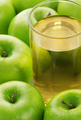 Glass with juice on a background of apples