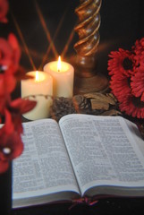 Naklejka na ściany i meble Student studying Bible at christmas by candlelight