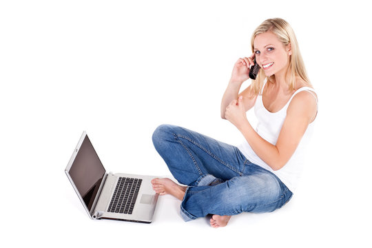positive junge frau beim telefonieren mit laptop