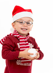 Junge mit Weihnachtsmütze und Schneebällen