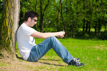 Young man with his cell phone at the park
