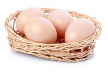 Raw eggs in basket isolated on white