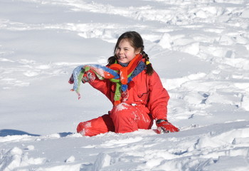 Fototapeta na wymiar sport d'hiver fillette accroupie sur la neige poudreuse