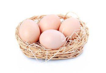 Raw eggs in basket isolated on white