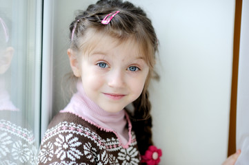 Beauty small girl with long dark braid  in winter sweater