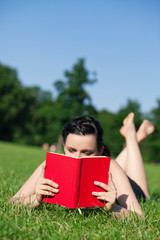Frau liest Buch auf der Wiese