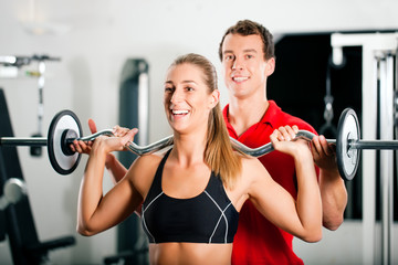 Personal Trainer und Frau im Fitnessstudio