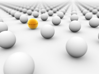 Golden ball surrounded by white ones with the focus on it.