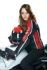 Sexy woman in a leather suit on motorcycle holding a helmet