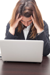 Businesswoman having a headache in front of her notebook