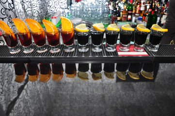 Row of four drinks of black vodka on the bar