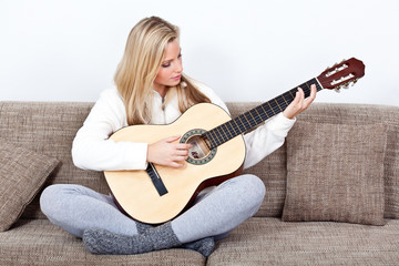 junge frau übt an der gitarre