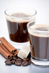 Duo d'espresso avec grains de café et bâtons de cannelle