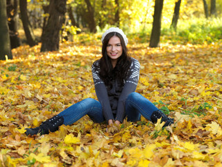 Beautiful woman working on laptop in park during autumn season