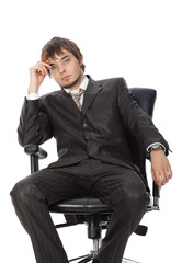 young attractive man with a cigar pensively sitting in an armcha